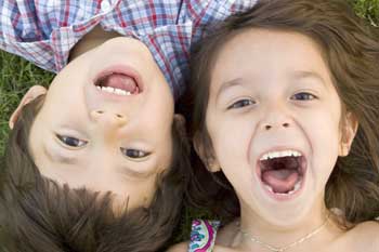 Zwei Kinder lachen die Kamera an